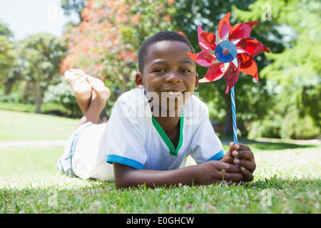 Little Boy tenendo la girandola nel parco sorridente in telecamera Foto Stock