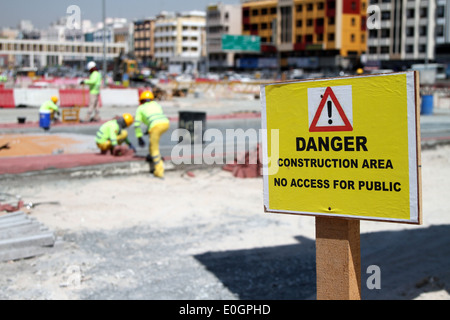 Lavoratori laici pietre per pavimentazione su un sito in costruzione nel quartiere di Deira di Dubai, Emirati Arabi Uniti. Foto Stock