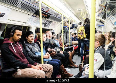 Pendolari su un tubo di Londra in treno. Foto Stock