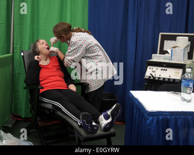 Schermate di infermiere donna senior per il cancro in bocca a un senior fair, New York, 8 maggio 2014, © Katharine Andriotis Foto Stock