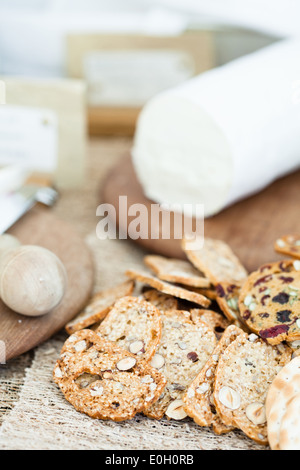 Vista dettagliata del cracker di secco con formaggi sul tagliere di legno in background Foto Stock