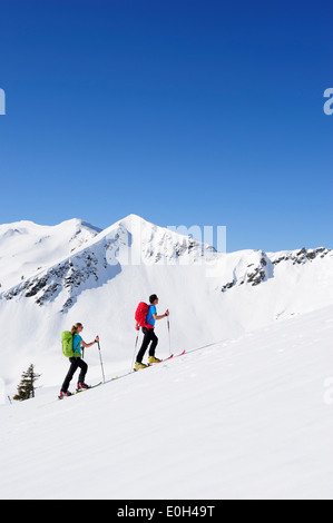 Due sciatori backcountry ascendente di Brechhorn, Großer Rettenstein in background, Kitzbuehel Alpi, Tirolo, Austria Foto Stock