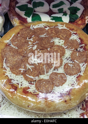 Prendere e cuocere il preparato salsiccia per pizza Pizza, D'Agostino Fruttivendolo, NYC, STATI UNITI D'AMERICA Foto Stock