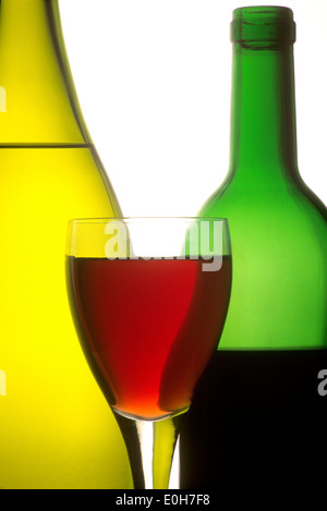 Le bottiglie di vino e un bicchiere di vino rosso, bianco e rosato Foto Stock