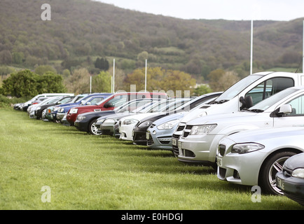 Linee di auto parcheggiate, SUV e minivan su un campo di erba utilizzato come parcheggio per un evento sportivo a Cheddar, Somerset, Regno Unito Foto Stock