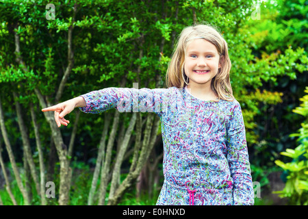 Bambina nei boschi che mostra qualcosa Foto Stock