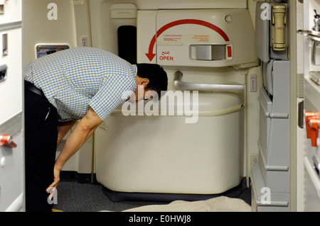 Musulmani maschi passeggero a bordo di un volo emirates prega verso la mecca Foto Stock