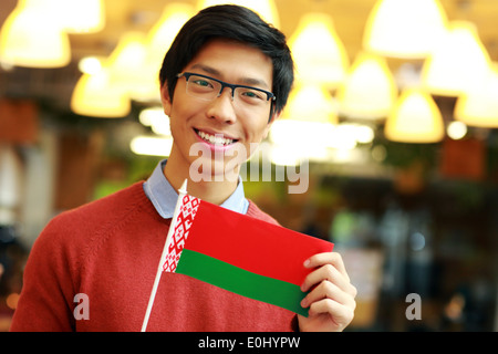 Felice giovane ragazzo asiatico holding bandiera della Bielorussia Foto Stock