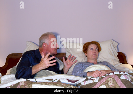 Coppia matura nel letto sostenendo Foto Stock