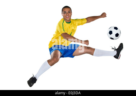 Calcio brasiliano player, saltando, giallo e blu Foto Stock