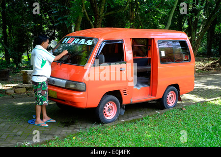 Uomo locale pulisce la sua mini bus al purwodadi giardini botanici vicino a malang east java indonesia Foto Stock