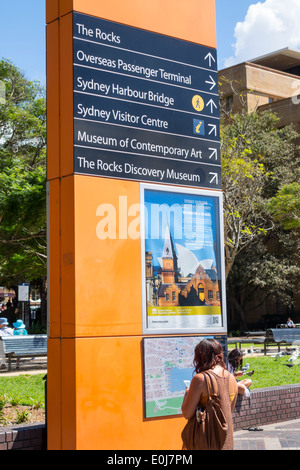 Sydney Australia,West Circular Quay,segno,frecce,direzioni,Museo di Arte Contemporanea,donna femminile,cercando,mappa,AU140310034 Foto Stock