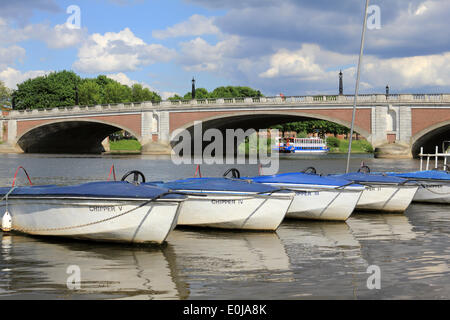 Hampton Court, Inghilterra, Regno Unito. 14 maggio 2014. È stata una giornata calda e soleggiata nella zona sud-ovest di Londra. Colorate barche a remi sono ormeggiato sulle rive del fiume Tamigi accanto a Hampton Court ponte dal Mitre Hotel che ha sofferto da inondazioni di quest'anno. Credito: Julia Gavin/Alamy Live News Foto Stock