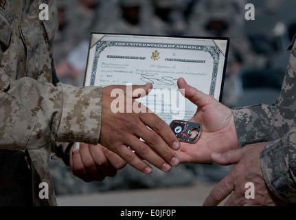 Un U.S. Marine riceve il suo certificato di naturalizzazione e di un comando coin dall esercito il Mag. Gen. Timothy McHale, vice commande Foto Stock