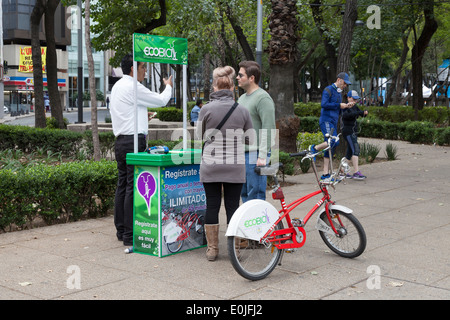 Giovane noleggiando una bicicletta da Ecobici lungo il Paseo De La Reforma sulla macchina gratuitamente domenica Foto Stock