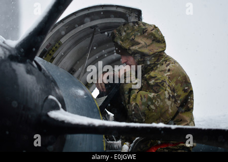 Un U.S. Air Force airman assegnato alla 455th Expeditionary Manutenzione aeromobili squadrone lavora sul motore di un C-130J Supe Foto Stock