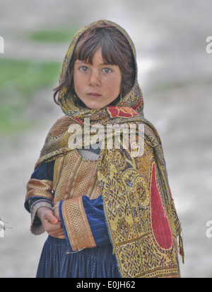 Una ragazza afghana guarda su come i paracadutisti dal 3 plotone, Apache pattuglia di società nel villaggio di Gorchek durante il funzionamento Naru Foto Stock