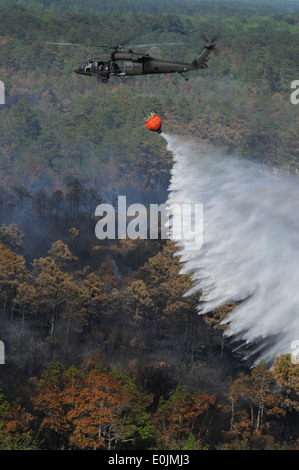 Un UH-60 Black Hawk elicottero utilizza un Bambi Bucket, riempito da un lago vicino, a goccia 600 galloni di acqua su incendi nei pressi di Myrt Foto Stock