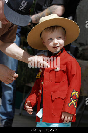 Vancouver, Canada. 14 Maggio, 2014. Un bambino mette sulla polizia montata uniformi durante l'evento open house presso un ufficio di polizia in Surrey Vancouver, Canada, 14 maggio 2014. Nella celebrazione della polizia nazionale settimana il Surrey forza di polizia ospitare eventi open house in diversi uffici distrettuali. Il caso di vetrine diversi veicoli della polizia e delle attrezzature quindi ad aumentare la sensibilizzazione della comunità e rafforzare i legami con la comunità. Credito: Liang Sen/Xinhua/Alamy Live News Foto Stock