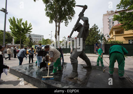 Ankara, Turchia. 14 Maggio, 2014. I lavoratori di Çankaya comune ripulire il Monumento al Minatore, mentre le persone lasciano fiori e segni di lutto per il disastro di una miniera di carbone a Soma (Manisa). Credito: Piero Castellano/Pacific Press/Alamy Live News Foto Stock