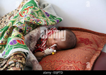 Un malato bambino afgano si appoggia, in corrispondenza della PUL-e Alam District Hospital, Sett. 4, pul-e Alam, provincia di Logar, Afghanistan. (Foto: PFC Foto Stock