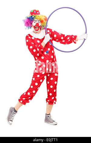 A piena lunghezza Ritratto di un maschio di clown tenendo un hula hoop Foto Stock