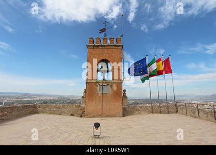 Le bandiere e una merlata torre campanaria nel punto più alto della Alcazaba fortezza dell'Alhambra di Granada, Spagna Foto Stock
