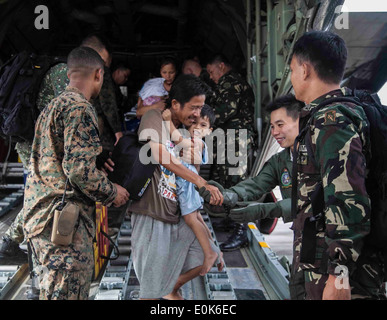 Stati Uniti Lancia Marine Cpl. Xavier L. Cannon e membri del Philippine Forze Armate assistere i civili sfollati dal tifone Haiyan Foto Stock