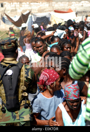 I cittadini haitiani que al progetto Handclasp ricevere rifornimenti da velisti assegnati per il dock anfibio sbarco nave USS Foto Stock