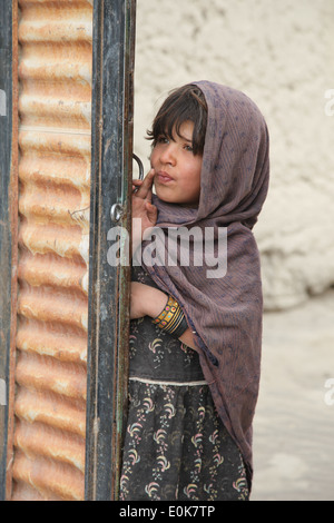 Una ragazza afghana guarda fuori dalla porta, come i soldati degli Stati Uniti che serve a una società, 2° Battaglione, 504th Parachute Reggimento di Fanteria, 1 Foto Stock