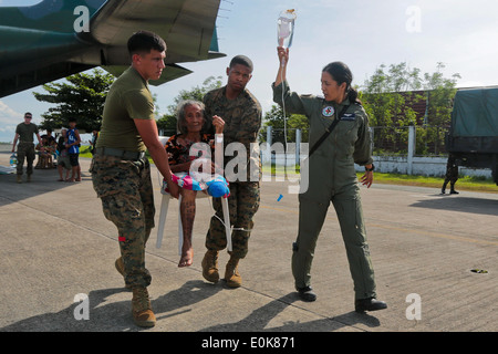 Stati Uniti Marines e delle forze armate delle Filippine aviatori assistere i profughi del personale di un Philippine Air Force KC-130J Hercul Foto Stock