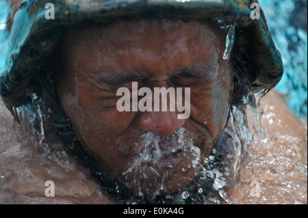 Marine Corps base Hawaii, Kaneohe Bay - un 3° Battaglione, seconda divisione marino indonesiano soffia acqua fuori del suo naso come egli surfa Foto Stock