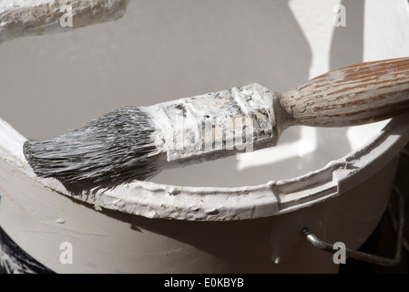 Un pittore professionista e decoratori spazzola di vernice sul bordo di un bollitore pittori Foto Stock