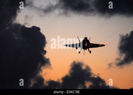 Un'F/A-18 Hornet eccellente rende il suo approccio finale prima di fare un arrestato atterraggio sul ponte di volo della Nimitz-class airc Foto Stock