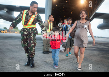 Un aviatore con il Philippine Air Force consente di offload civili filippini al di fuori di un'U.S. Marine C-130 Hercules aeromobili a Villam Foto Stock