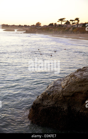 Un gruppo di surfers off nella distanza attende pazientemente per la prossima onda lungo la corsia di piroscafi a Santa Cruz, in California. Foto Stock