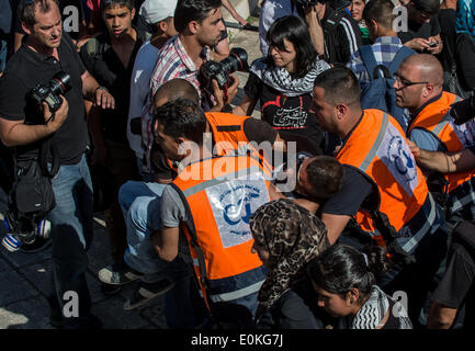 Jurusalem, Israele. 15 Maggio, 2014. Un manifestante ferito viene evacuato dal sito di un rally che segna il sessantesimo anniversario della la Nakba giorno o il giorno della "catastrofe" in arabo, una commemorazione annuale per il loro lamento su Israele la costituzione nel 1948 ed il loro spostamento durante la guerra nella sua scia, a Damasco Gate nella Città Vecchia di Gerusalemme, il 15 maggio 2014. Un israeliano portavoce della polizia irachena ha detto giovedì che cinque manifestanti sono stati arrestati durante la manifestazione non autorizzata qui il giovedì. Credito: Xinhua/Alamy Live News Foto Stock