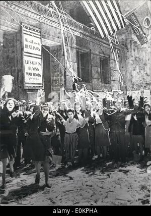 Maggio 05, 1945 - Abbiamo ancora a leccare il Giappone: una sobria nota viene introdotto alla finanziaria distrait lavoratori a New York per celebrare la fine della guerra in Europa. È in forma di segnali di avvertimento celebranti che vi è ancora un altra guerra per vincere la guerra e suoni da acquistare. Foto Stock