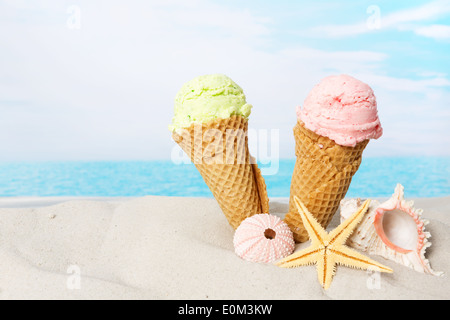 Due coni gelato e conchiglie nella sabbia sulla spiaggia Foto Stock