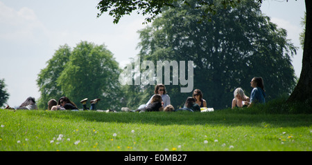 Persone lounging circa in un parco al sole Foto Stock