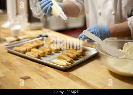 Rendendo éclairs da zero in pasticceria Foto Stock