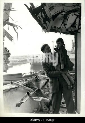 25 ottobre 1956 - 25-10-56 quattro anno vecchia ragazza manca la morte da pollici. Quattro anni di Judith il cofano è stato addormentato in bridge house cabina del 8.000 ton freighter danese, Nordvest. Nel Tamigi, off Blackwell punto, la nave entrò in collisione con il British nave da carico, Benmardhvi (7,845 tonnellate), e la prua spazzato via l'ala del ponte, a destra accanto alla sua cabina. La foto mostra: il Sig. David cappa, un dipendente del Regno Africa Company, detiene Judith in questa immagine presa accanto alla sua cabina in West India Dock oggi. La madre e la sorella erano anche in viaggio. Foto Stock