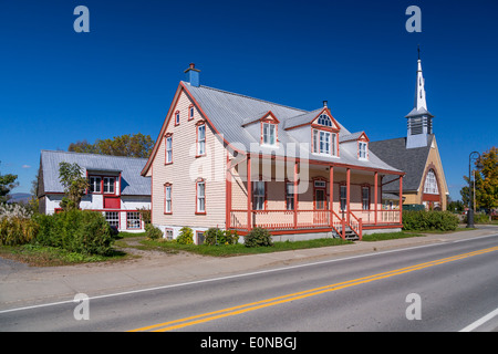 Una strada con un'isola home nel villaggio di Saint Pierre sull isola di Ile d'Orleans, Quebec, Canada. Foto Stock