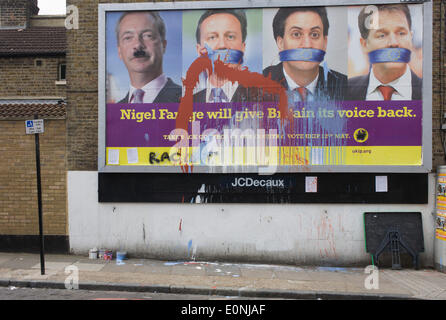 Londra, Regno Unito. 17 Maggio 2014: schizzato vernice anti-adesione all'UE "UK Independence Party (UKIP) billboard politico che mostra leader Nigel Farage (con intonacato Hitler baffi) e un imbavagliato il Primo Ministro David Cameron, leader del partito laburista ed Milliband e (coalition) Vice PM Nick Clegg - tutti in silenzio contro il bullismo Unione europea, visto in oriente Dulwich - Una relativamente benestante quartiere di South London. L'annuncio viene visualizzato prima delle elezioni europee il 22 maggio. Copyright Richard Baker / Alamy Live News. Foto Stock