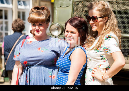 Haworth, West Yorkshire, UK. 17th May 2014. People dress in 1940s pose for a photograph. Haworth, a small village in the city of Bradford in West Yorkshire has held the first day of its 1940s weekend on Saturday, March 17, 2014. Good weather brought hundreds into the village for this event where locals and visitors don wartime attire. Credit:  Christopher Middleton/Alamy Live News Foto Stock
