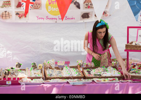 Haworth, West Yorkshire, UK. 17th May 2014. A woman in a colourful dress prepares her stall for the event. Haworth, a small village in the city of Bradford in West Yorkshire has held the first day of its 1940s weekend on Saturday, March 17, 2014. Good weather brought hundreds into the village for this event where locals and visitors don wartime attire. Credit:  Christopher Middleton/Alamy Live News Foto Stock