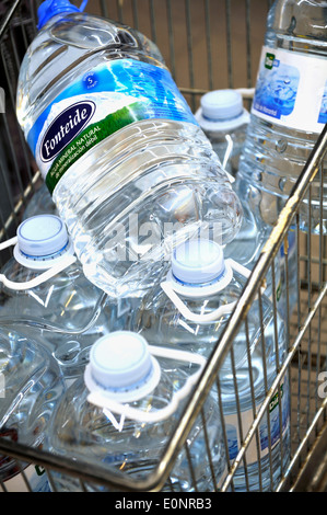 Bottiglie di acqua nel carrello per supermercati Foto Stock