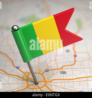 Piccola bandiera del Mali su uno sfondo raffigurante una mappa con il fuoco selettivo. Foto Stock