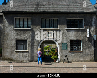 Signora guardando attraverso il passaggio a volta del Sandnes ospedale, con datestone di 1659, Highgate, Kendal Cumbria, England Regno Unito Foto Stock