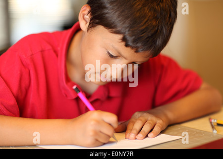 Ragazzo giovane disegno per i suoi compiti - profondità di campo Foto Stock